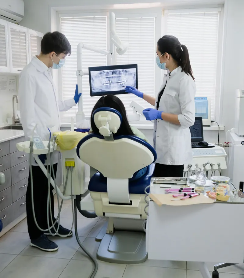 Dentists reviewing a digital panoramic X-ray with a patient