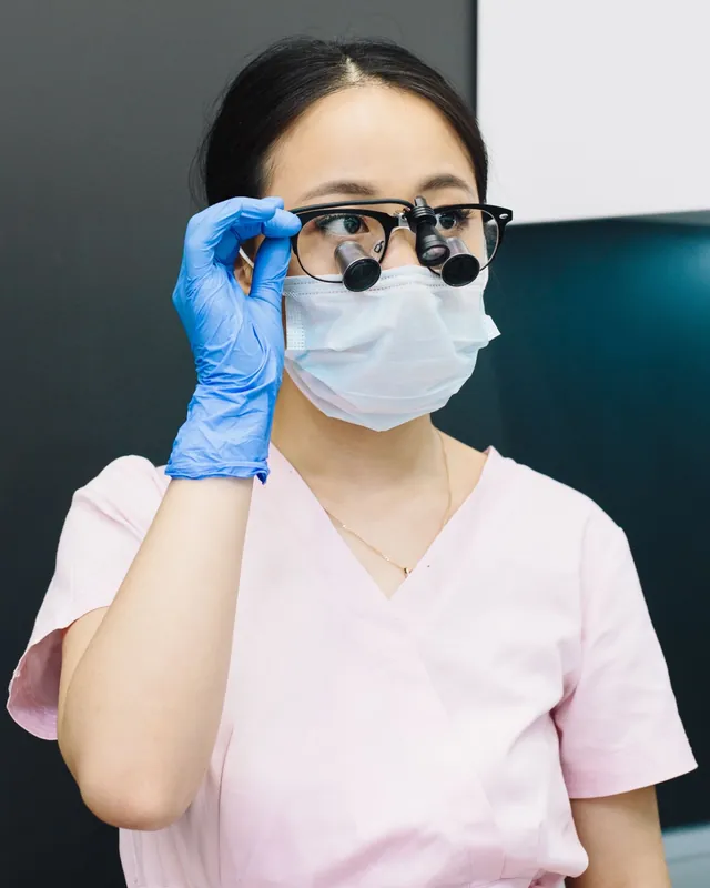 Lina Tran, dental hygienist, adjusting her magnification loupes